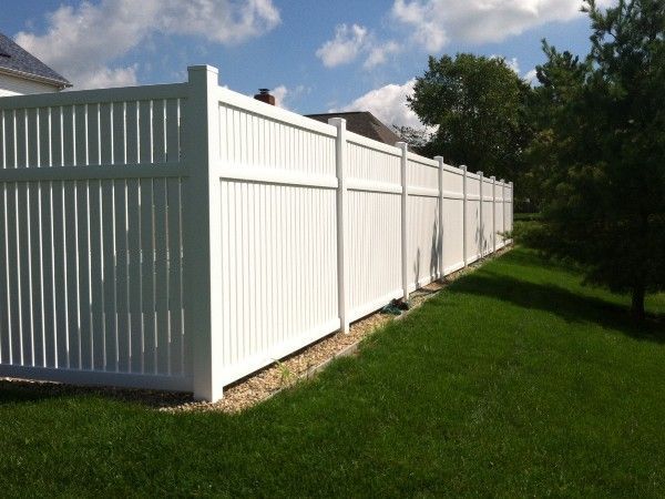 A white fence surrounds a lush green yard