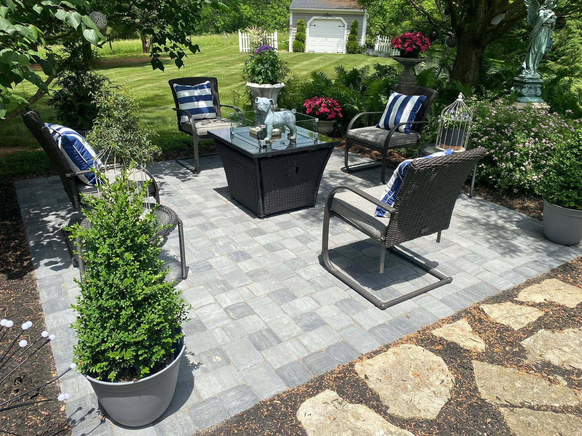 A patio with a table , chairs , and potted plants.