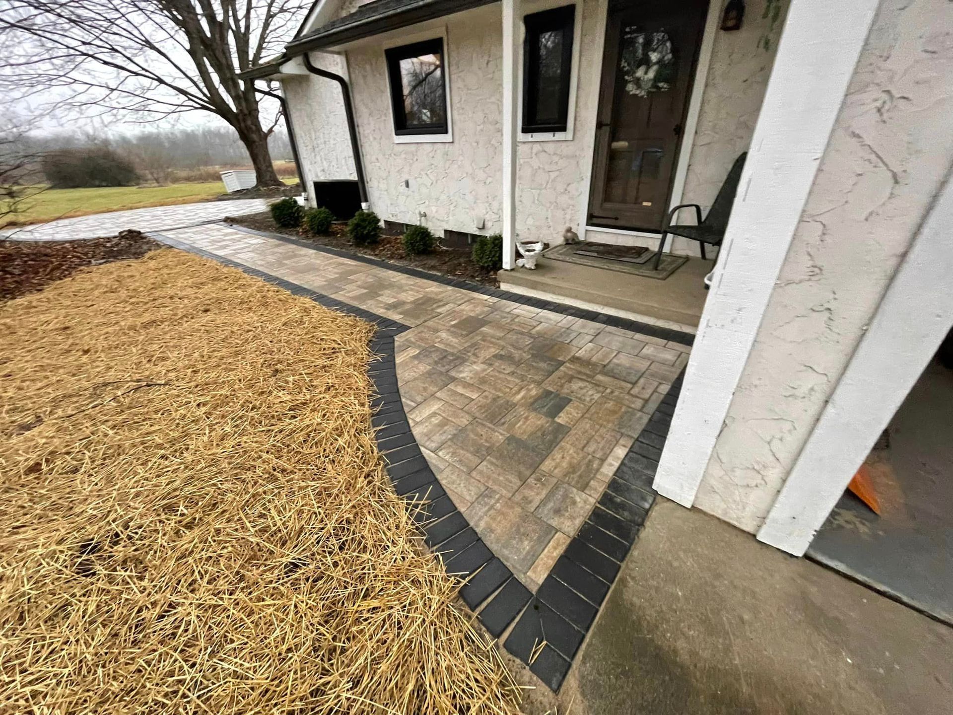 A white house with a brick walkway leading to the front door.
