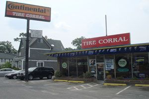 Continental Tire Corral storefront with red sign and parked cars in front