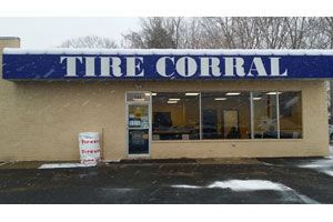 Tire Corral storefront with blue sign above windows and snowy ground outside