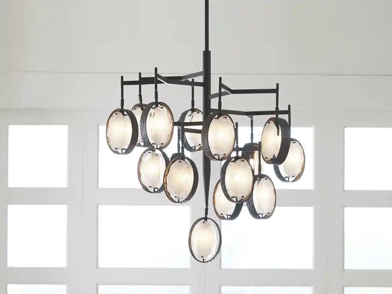 A chandelier is hanging from the ceiling in front of a white wall.