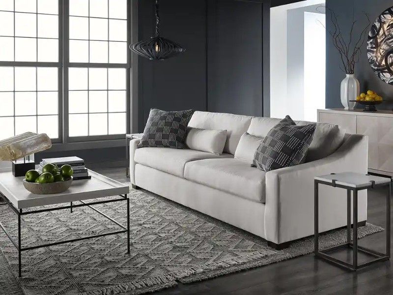 A living room with a white couch and a white coffee table.