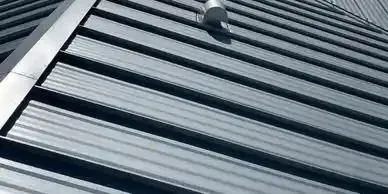 Gray metal roof with parallel ridges and a small pipe.