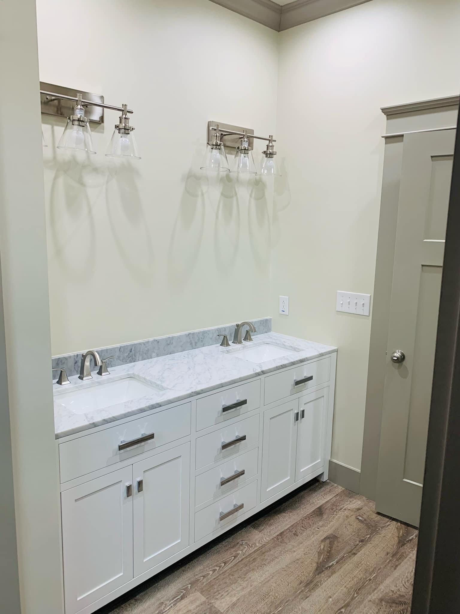 A bathroom with two sinks and a door