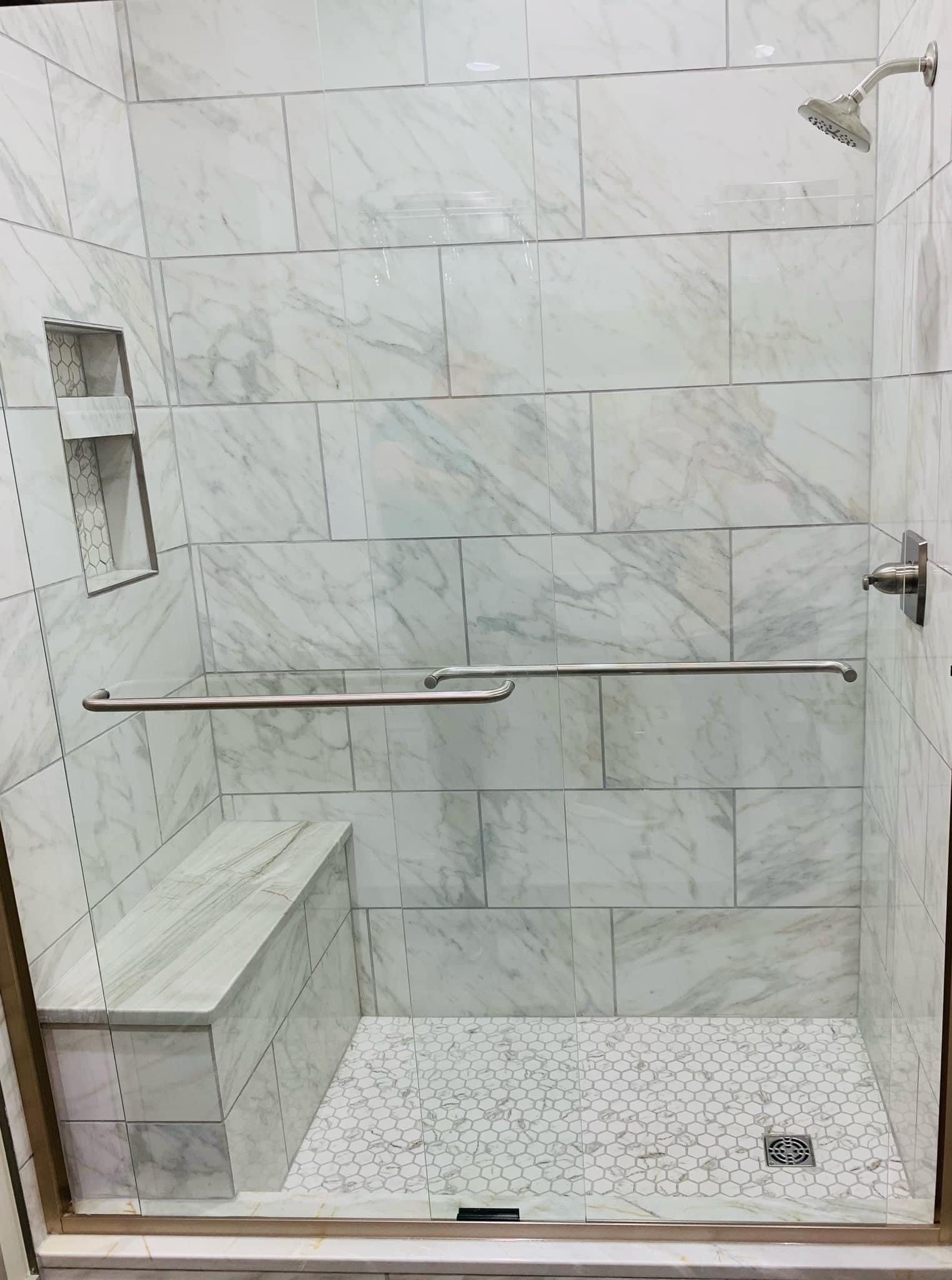 A walk in shower with a bench and a shower head