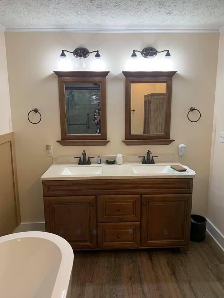 A bathroom with two sinks, two mirrors and a bathtub