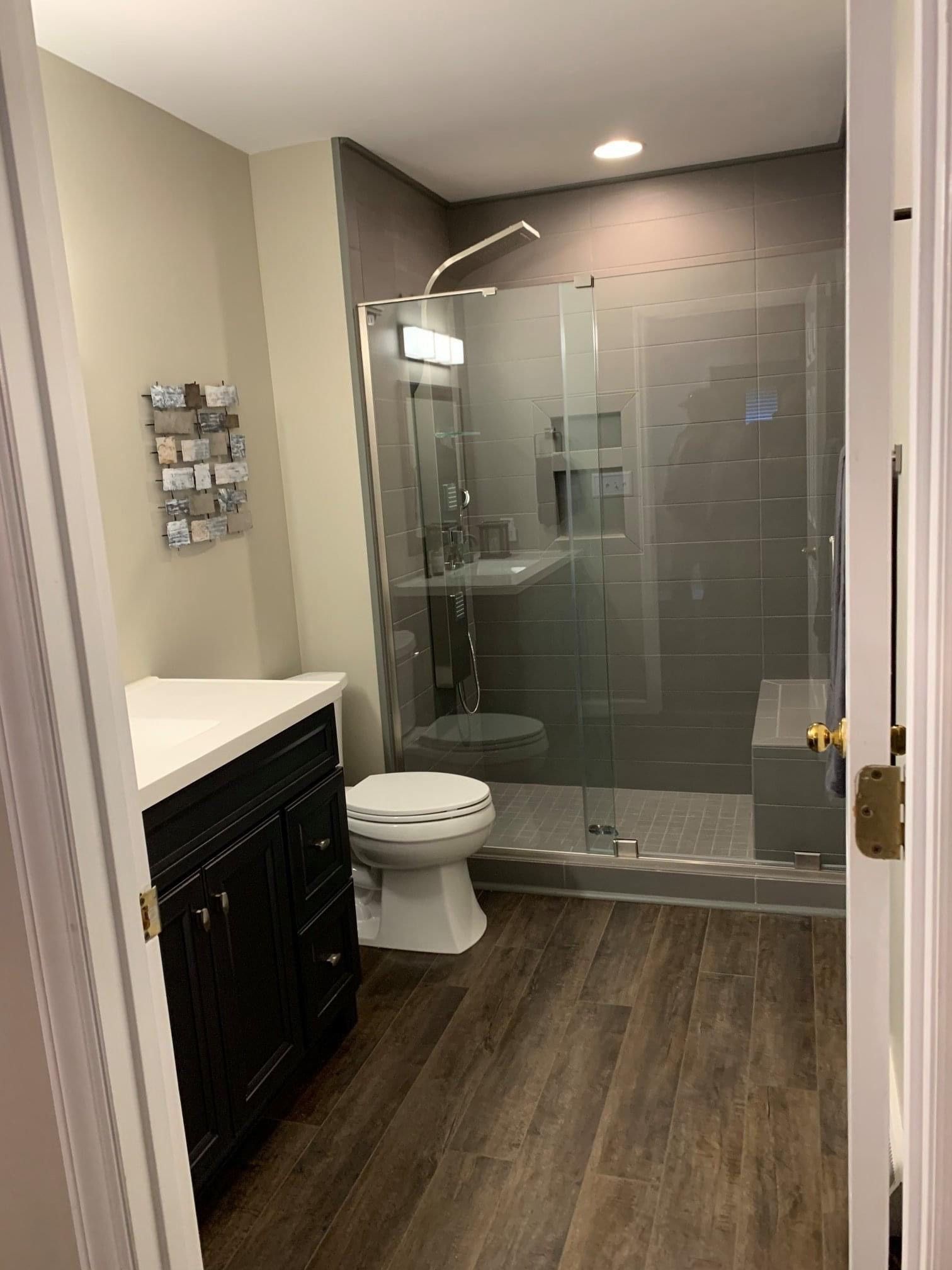 A bathroom with a toilet, sink, and walk in shower