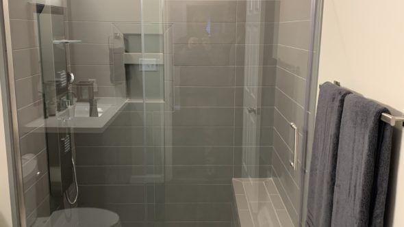 Bathroom with a toilet, sink, and walk in shower