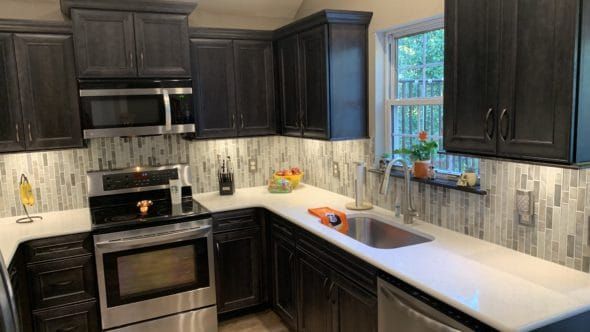 Kitchen with black cabinets, stainless steel appliances