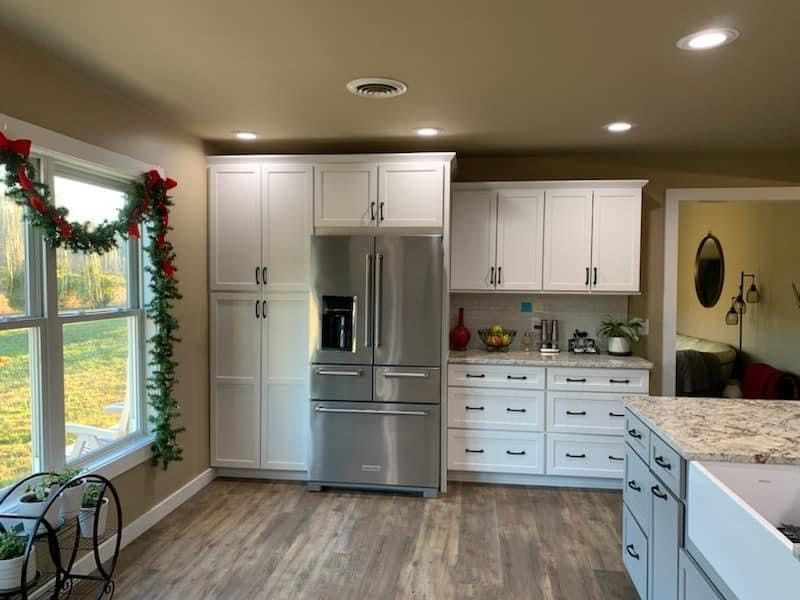A kitchen with white cabinets and stainless steel appliances