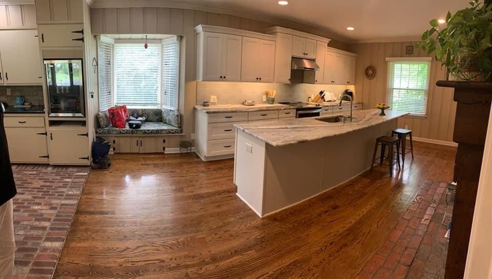 White kitchen cabinet, island and wood flooring