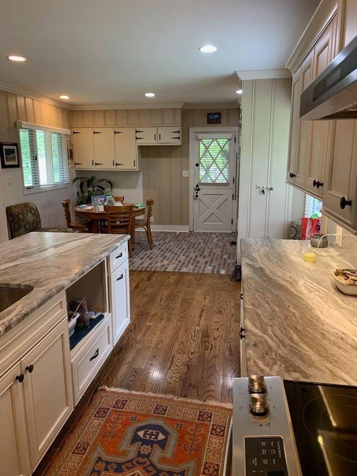 A kitchen with a rug on the floor and a stove