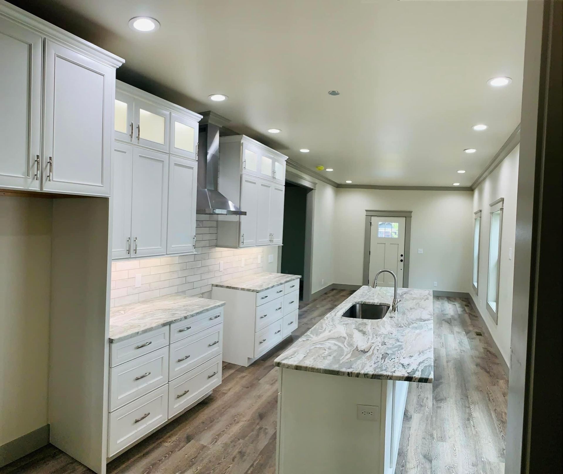 Kitchen with white cabinets, granite counter tops, and a large island