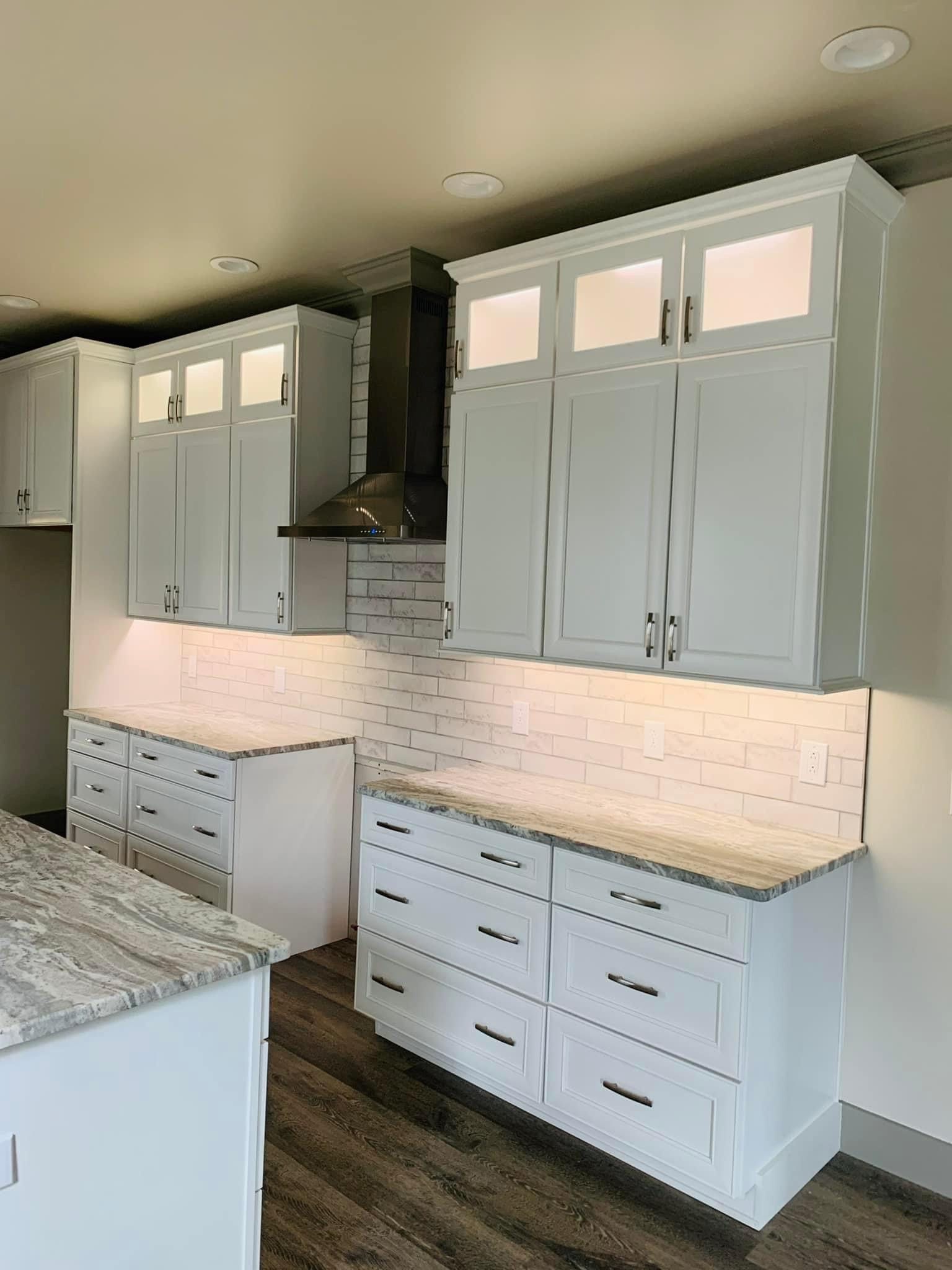 A kitchen with white cabinets and granite counter tops