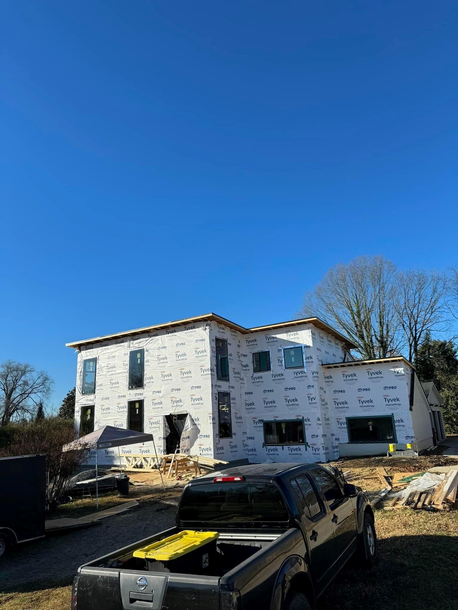 A truck is parked in front of a house under construction