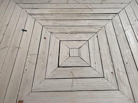 White painted wooden floor arranged in concentric squares.