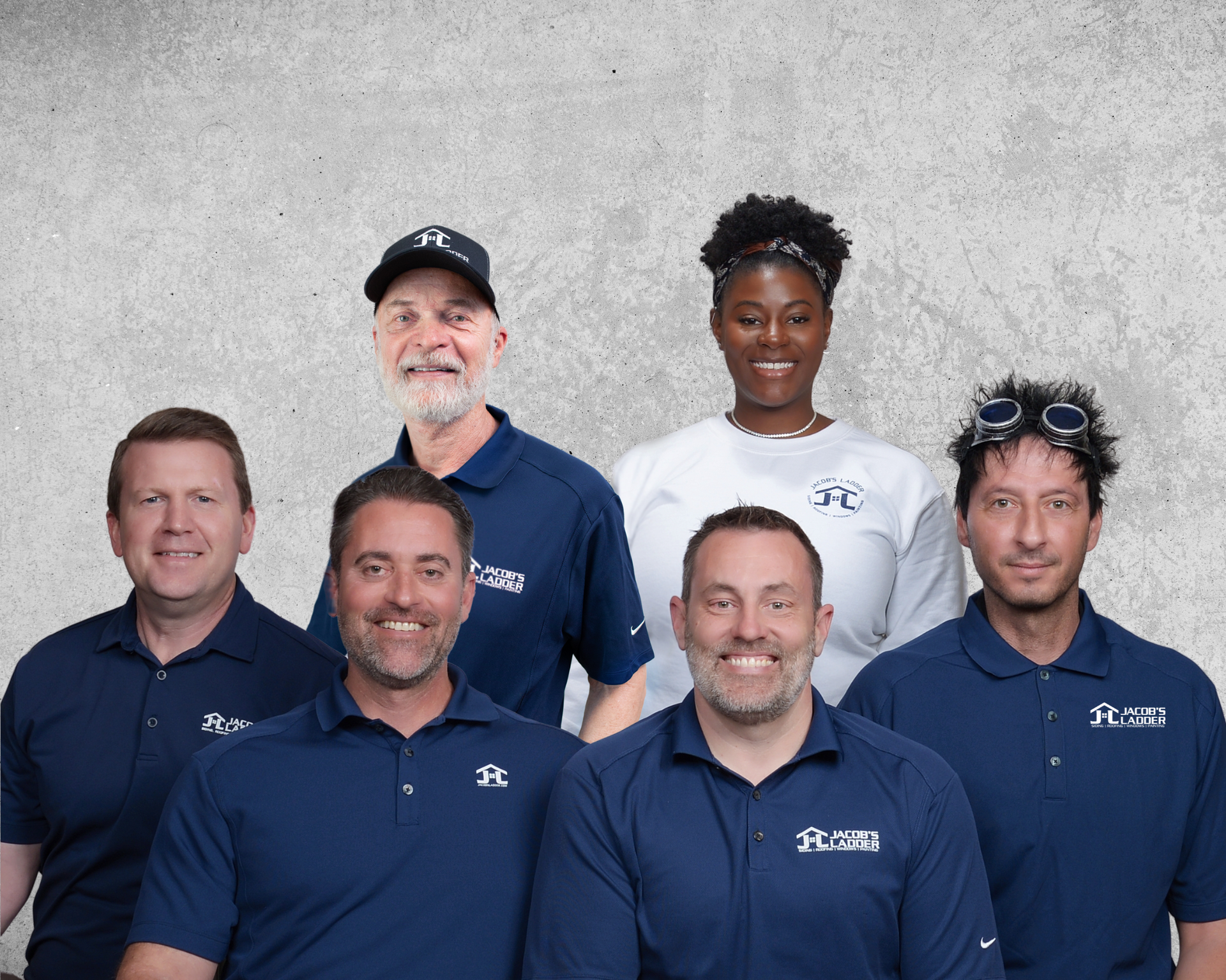 Group of six people wearing blue shirts with a logo, posing in front of a gray wall.
