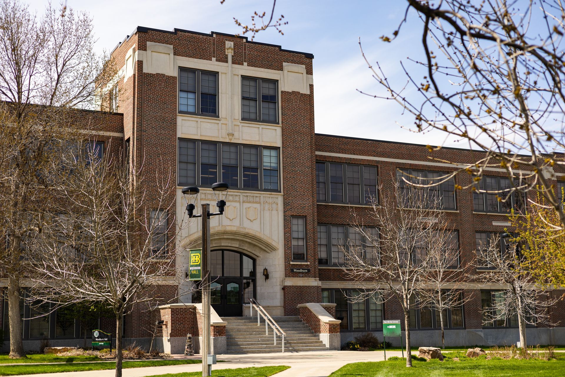 Brick building with arched entrance and multiple windows, likely a school.