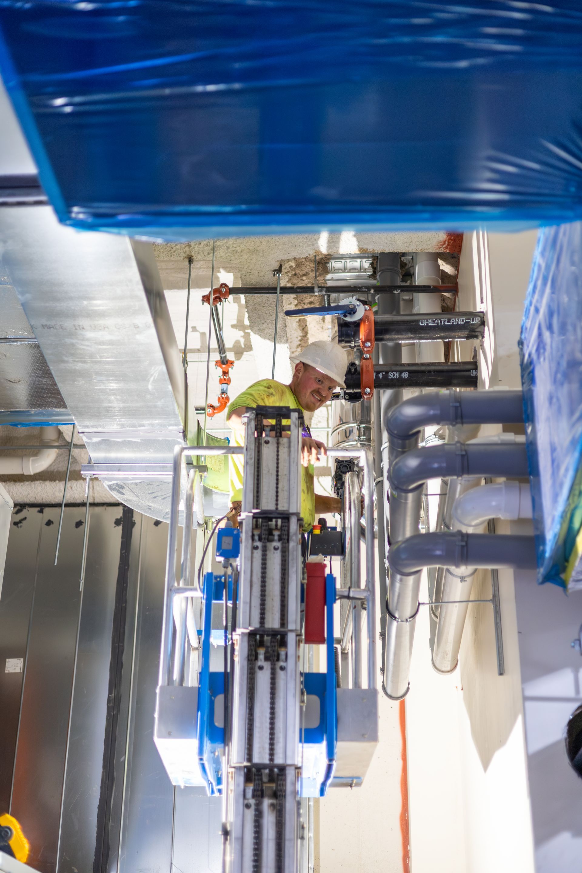 Complex network of pipes, valves, and mechanical components, possibly part of an industrial system, with blue and silver elements.