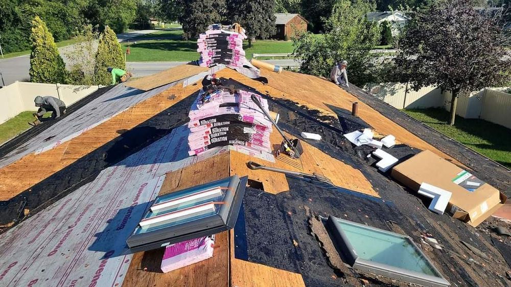 A roof with two skylights being installed on it.