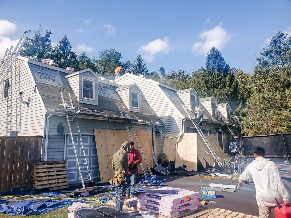 A group of people are working on the roof of a house.