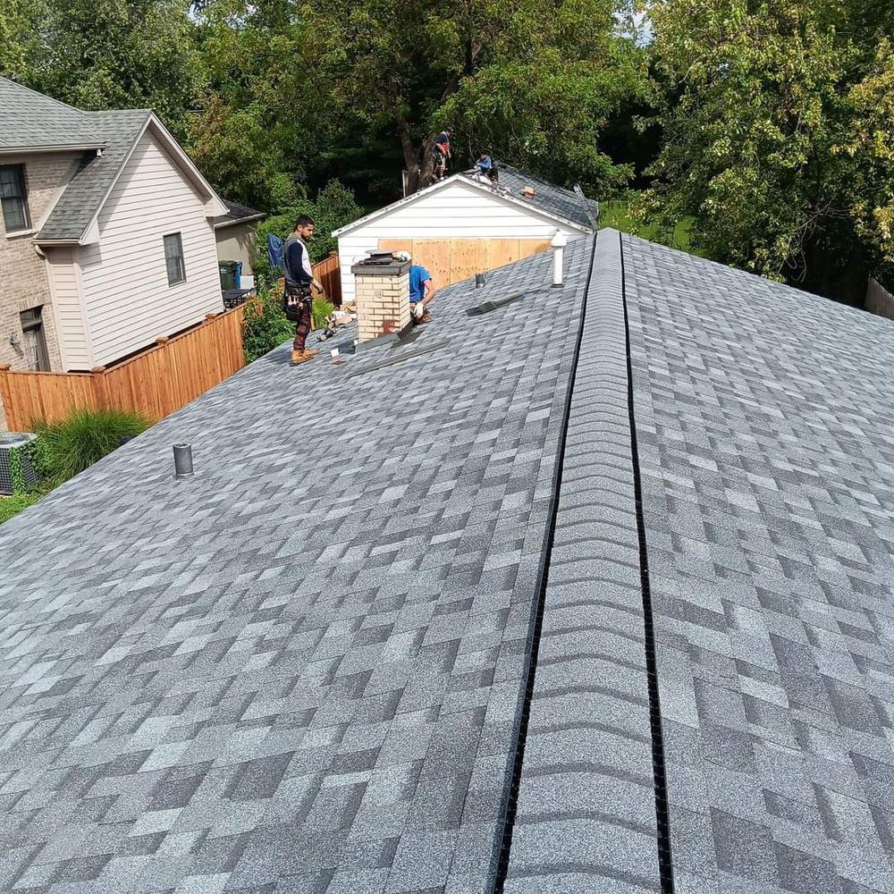 A man is standing on the roof of a house.