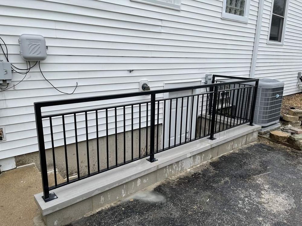 A white house with a black railing on the side of it