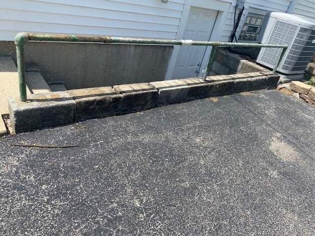 There is a green railing on the side of the road