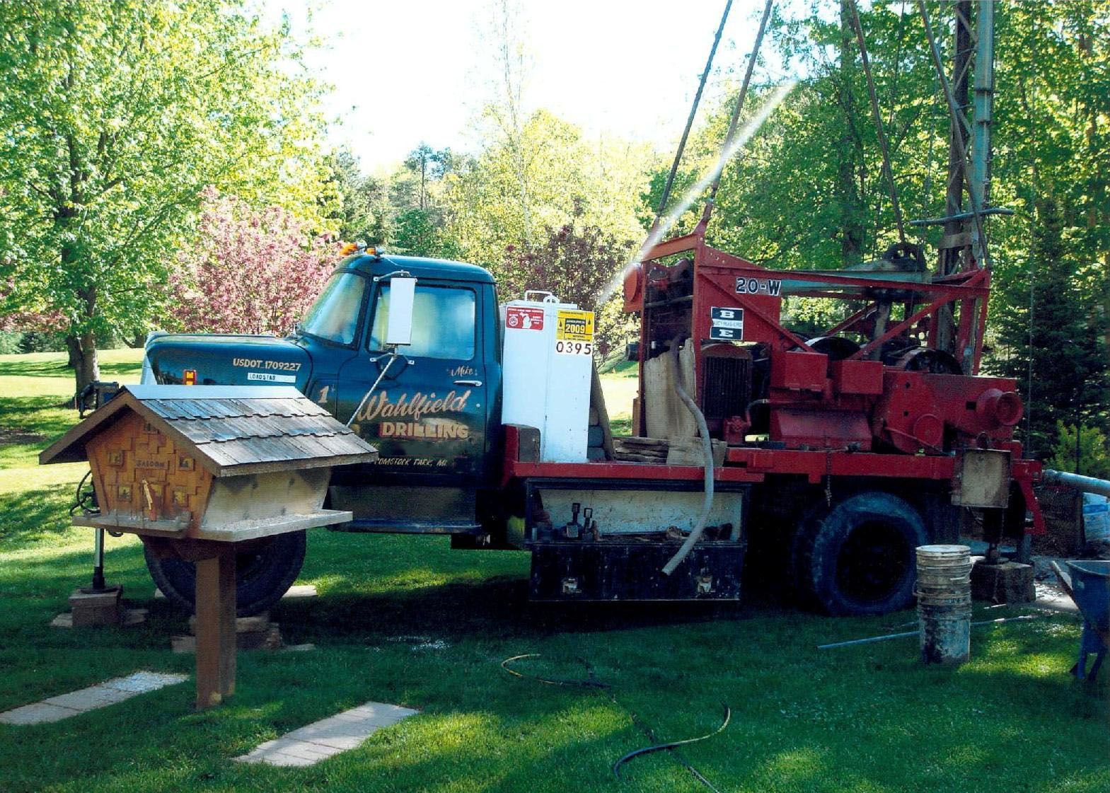 A blue truck with a red and white machine on the back of it