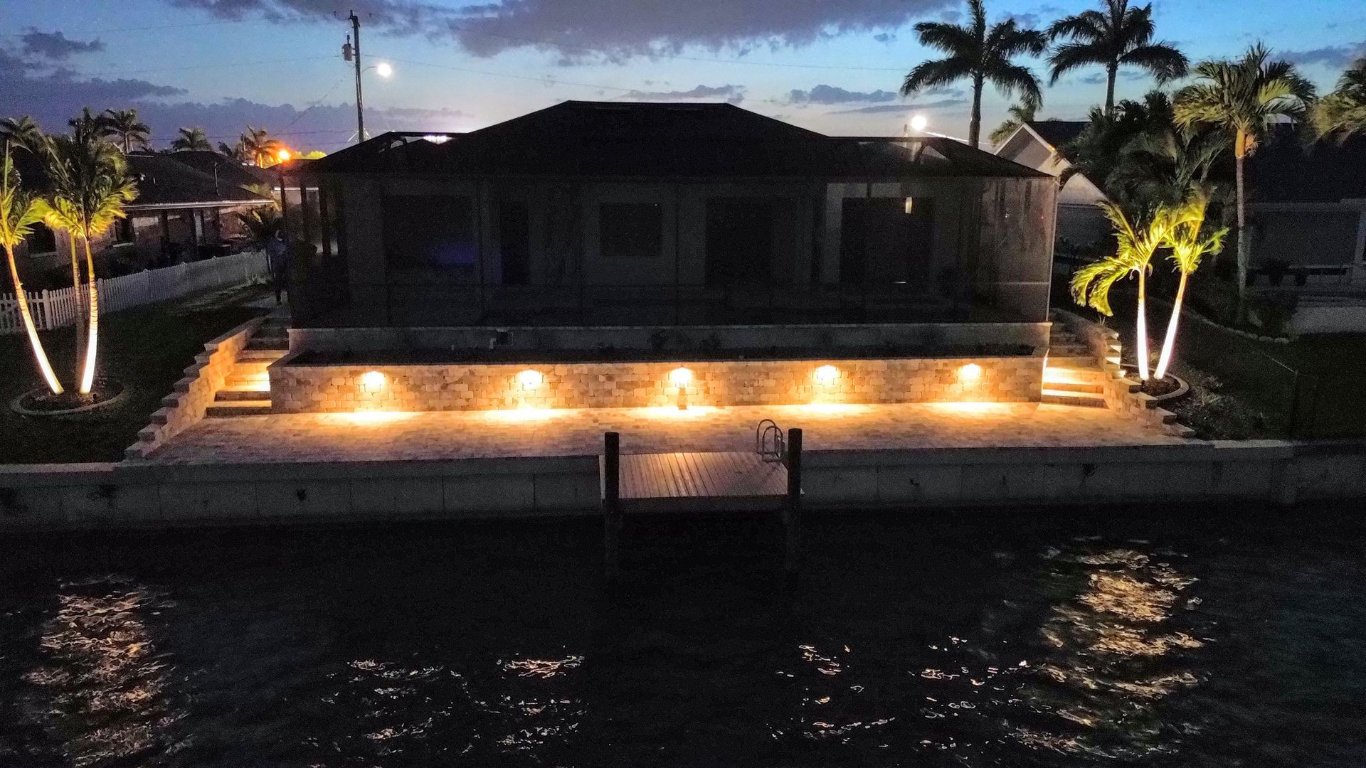 A house sitting on top of a body of water at night