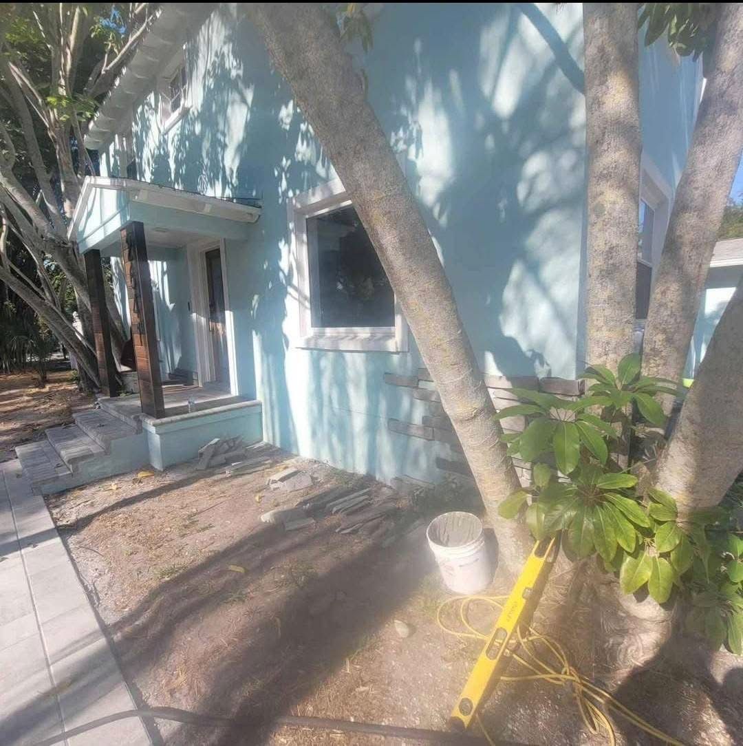 A blue house with a tree in front of it