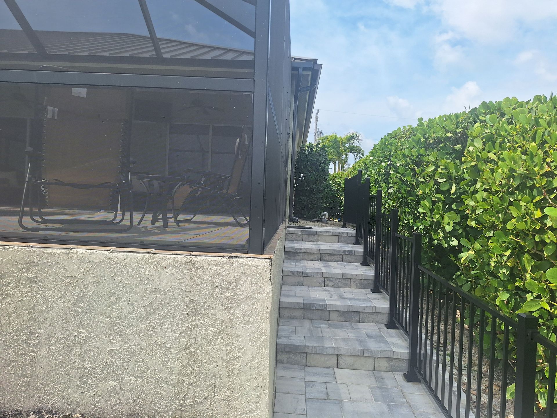 A house with a screened in porch and stairs leading up to it.