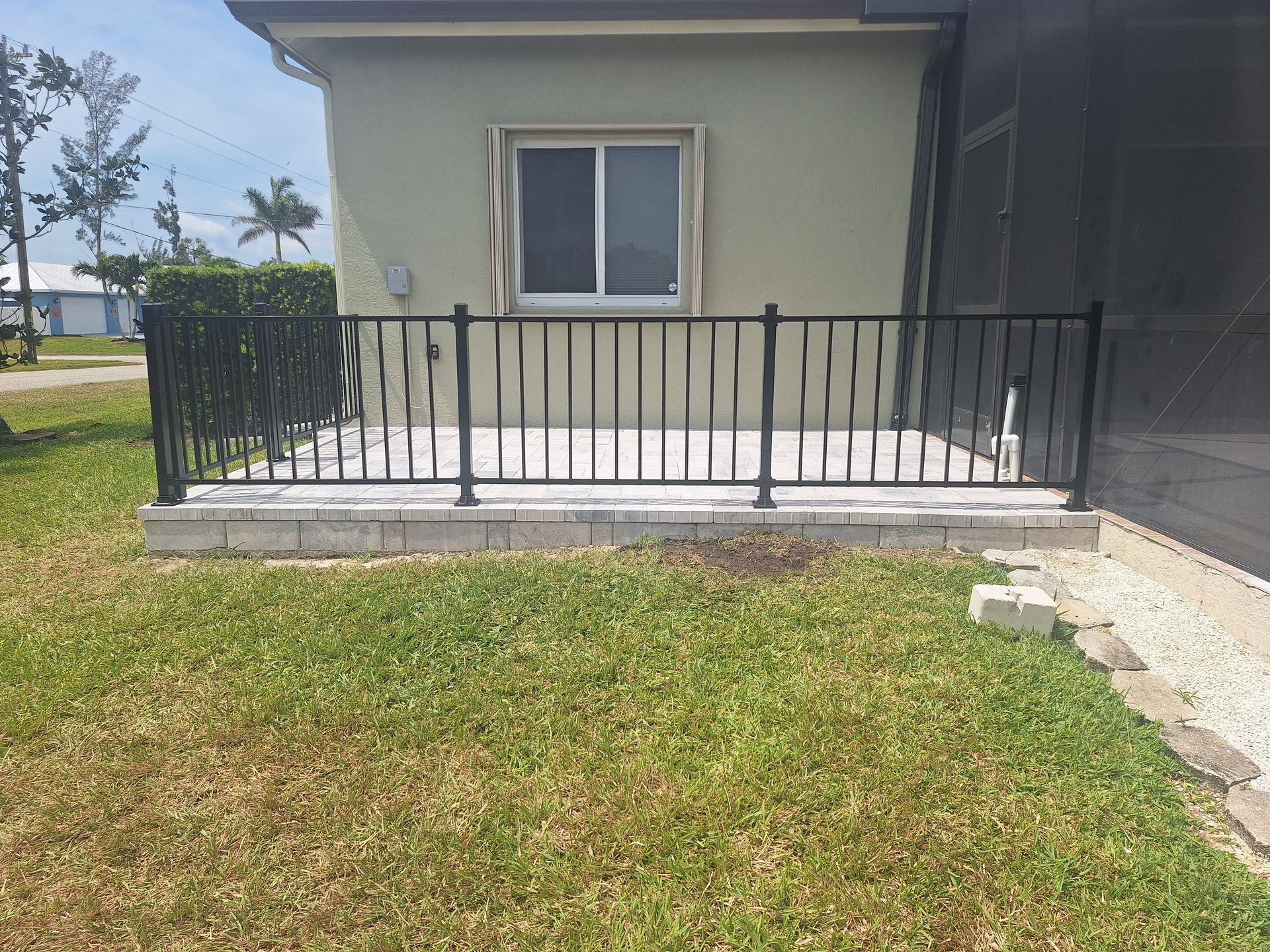 A house with a balcony and a fence in front of it.