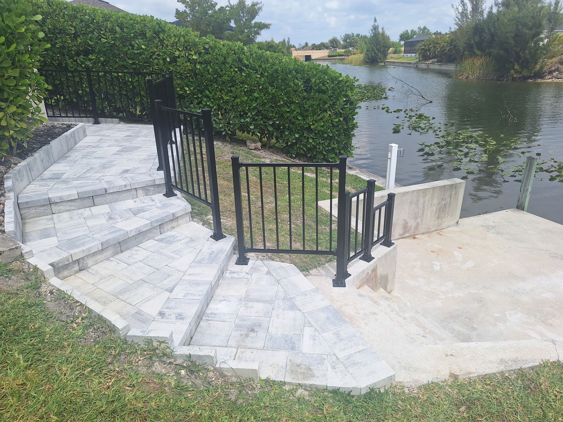 A staircase leading to a lake with a gate and a fence.