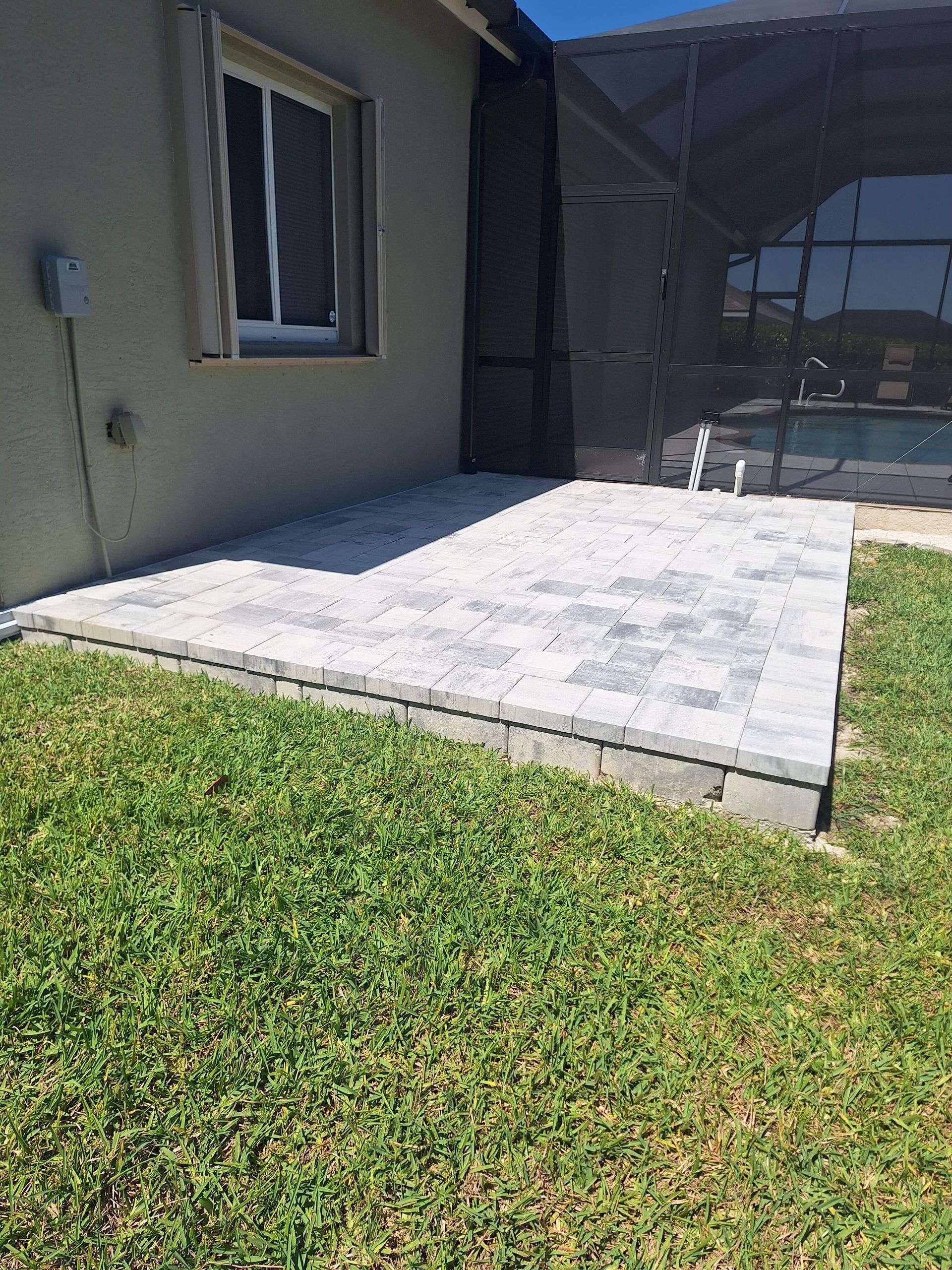 A patio is being built in the backyard of a house.