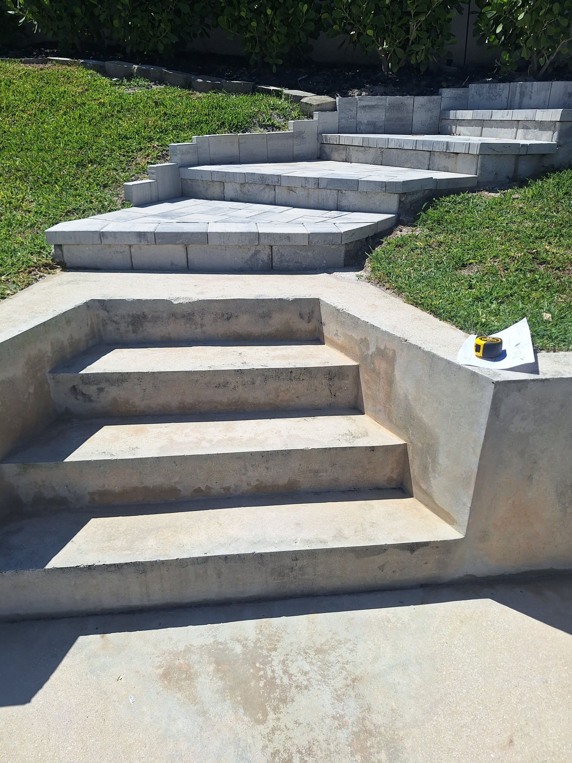 A set of concrete steps leading up to a grassy hillside