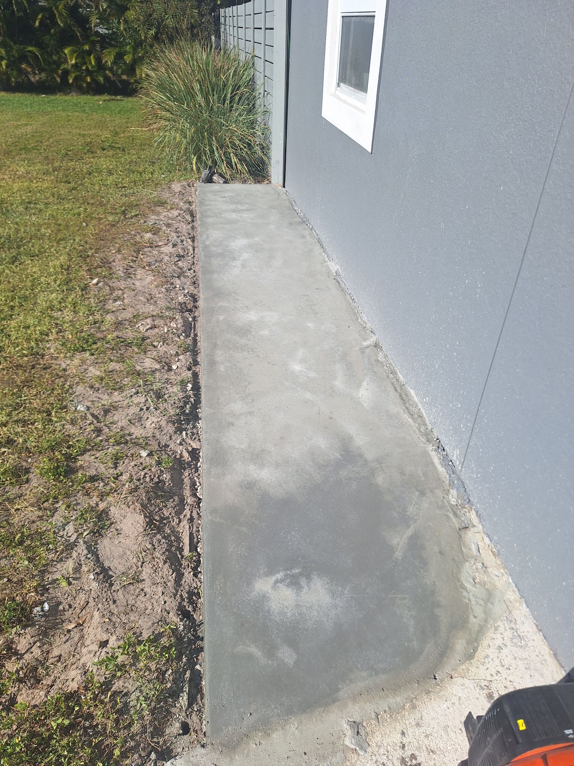 A sidewalk is being built in front of a house.