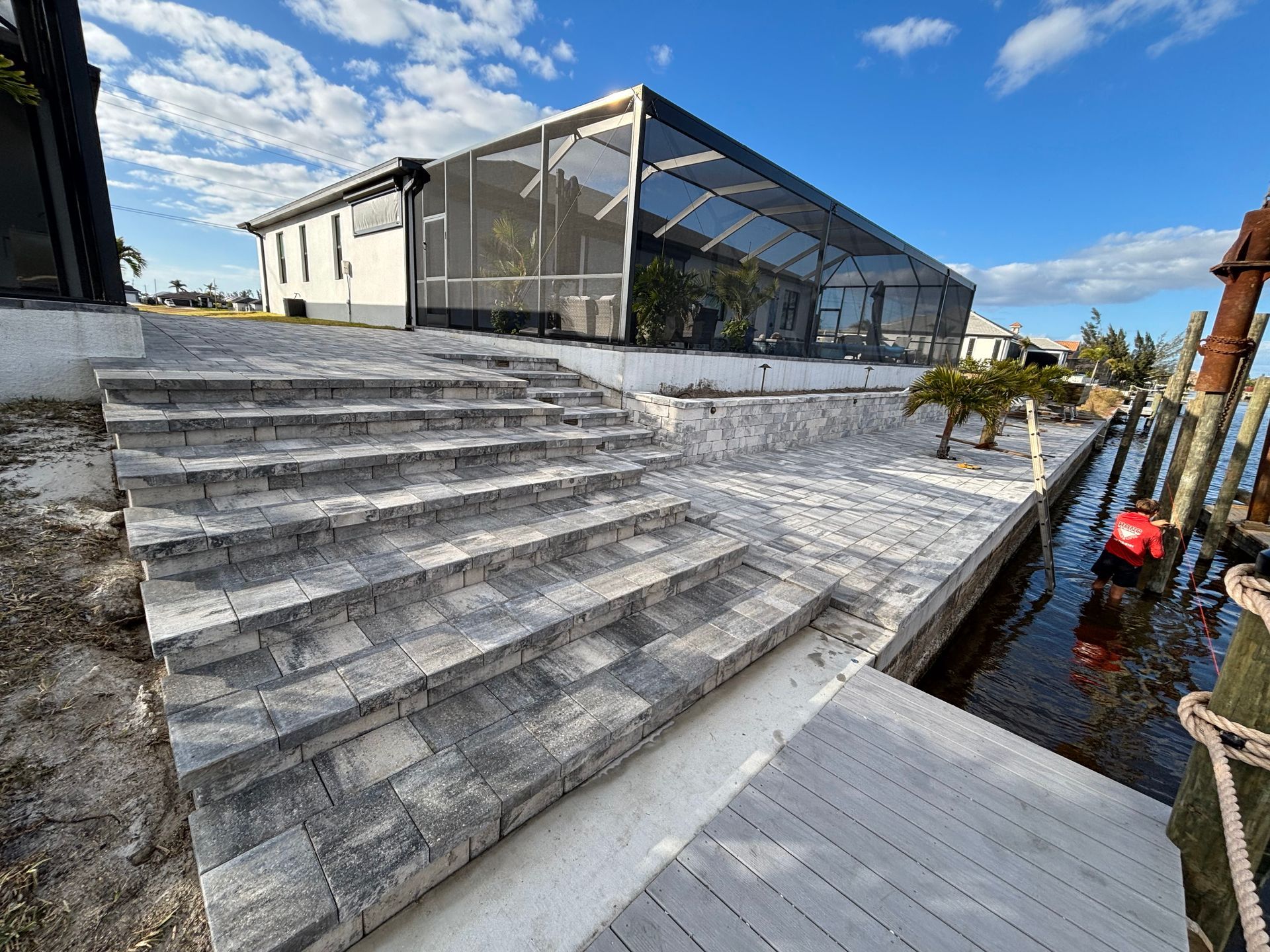 A staircase leading up to a house next to a body of water.