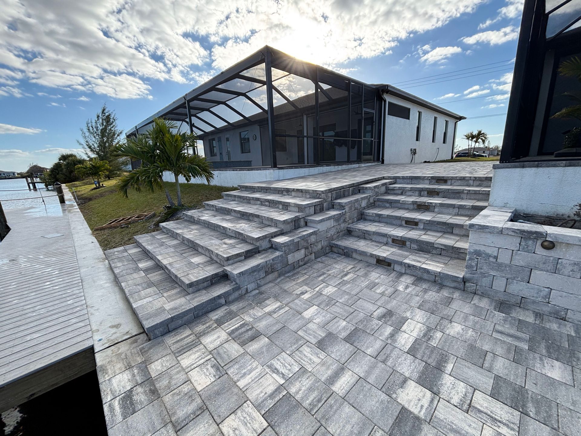 A house with a screened in porch and stairs leading up to it.