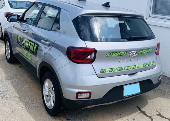 Silver Hyundai Venue SUV with green text graphics.