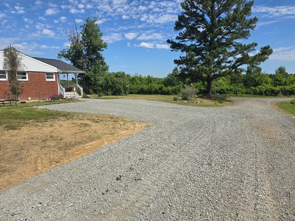 A gravel driveway leading to a brick house