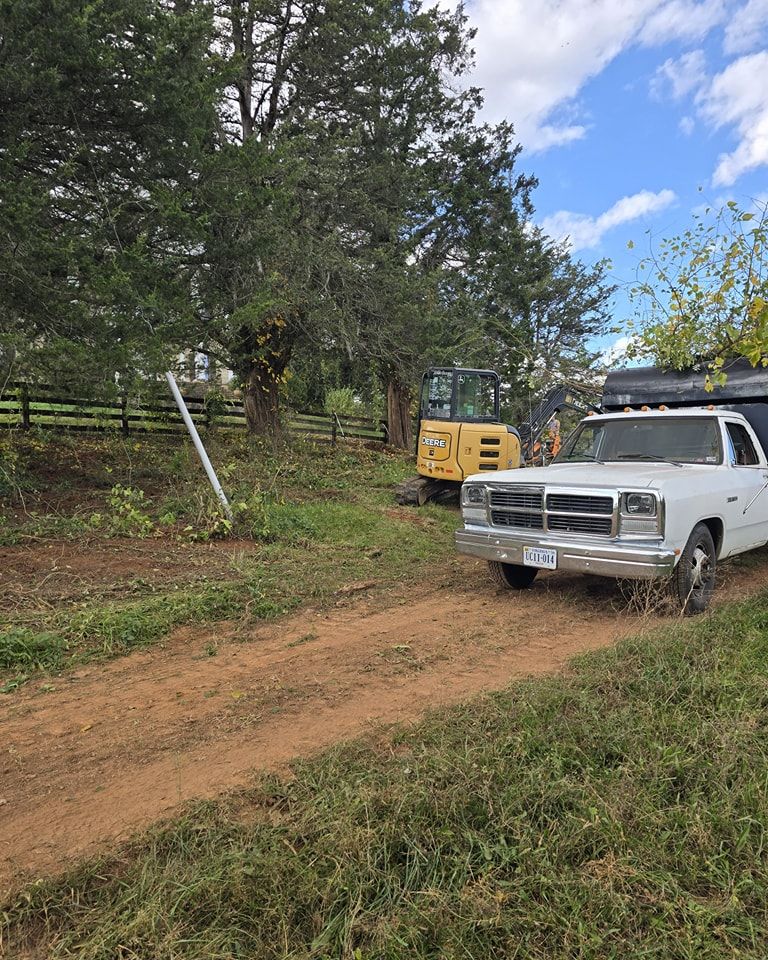 A white truck is parked on the side of a dirt road.
