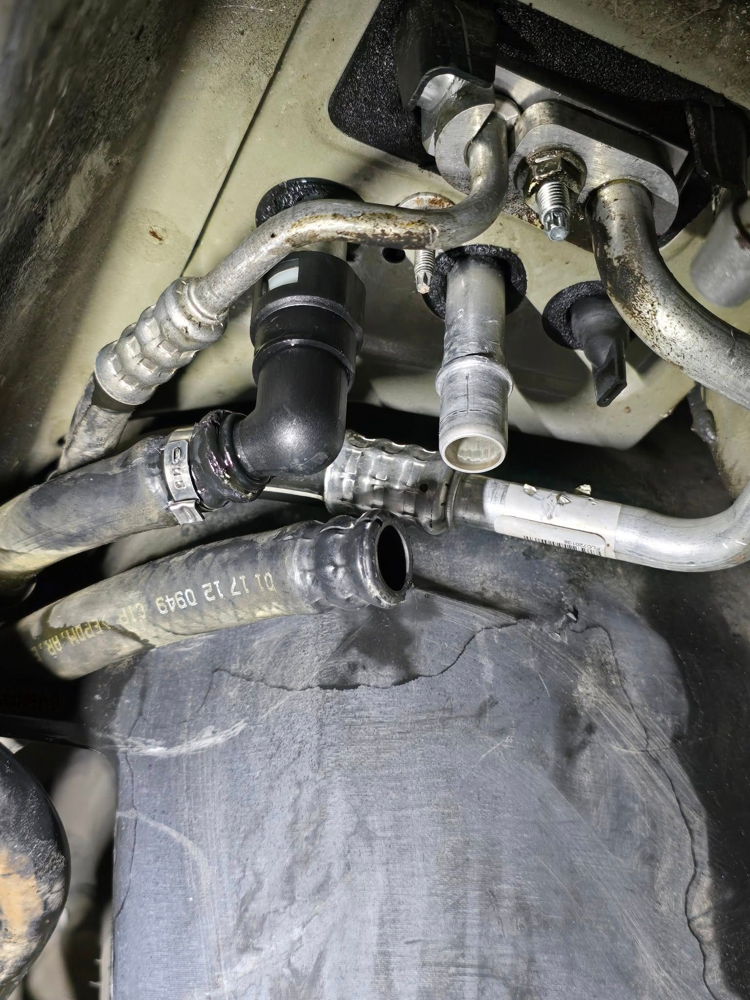 Close-up of dusty car engine hoses and metal pipes under the hood