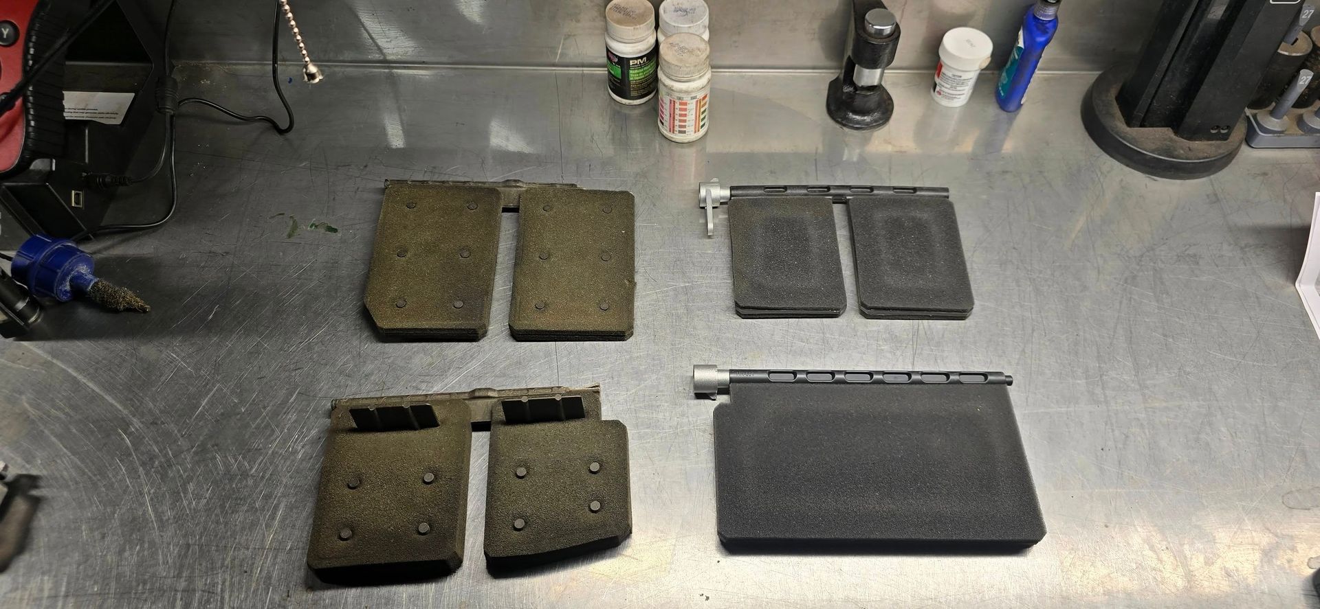 Several vehicle floor mats and cargo mats laid out on a gray carpeted floor in a garage.