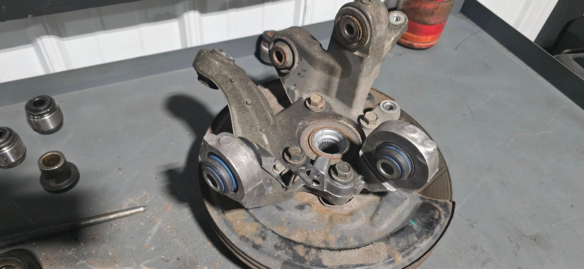 Rusty mechanical parts on a workbench, with gears and bearings scattered nearby.