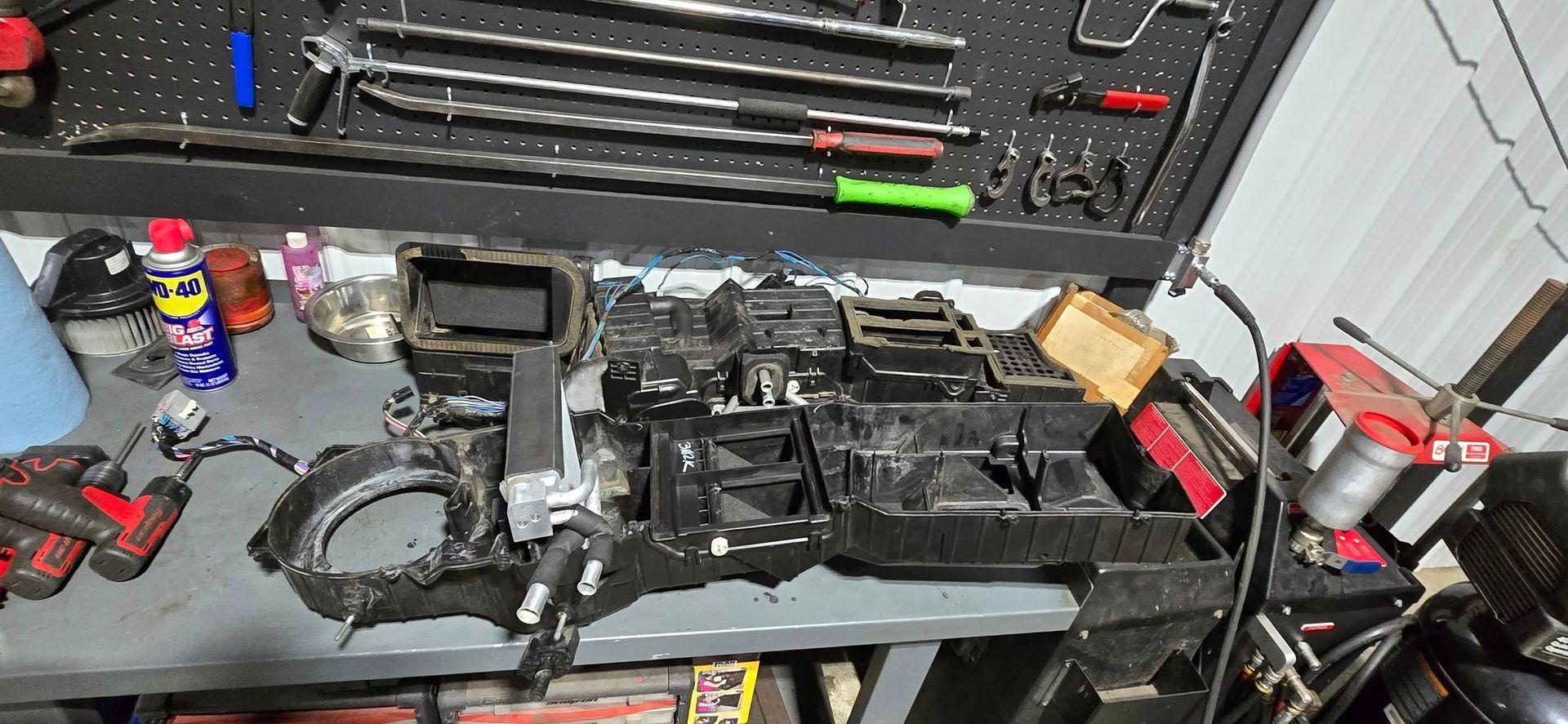 A tactical case and workbench covered with firearm parts, tools, magazines, and accessories.