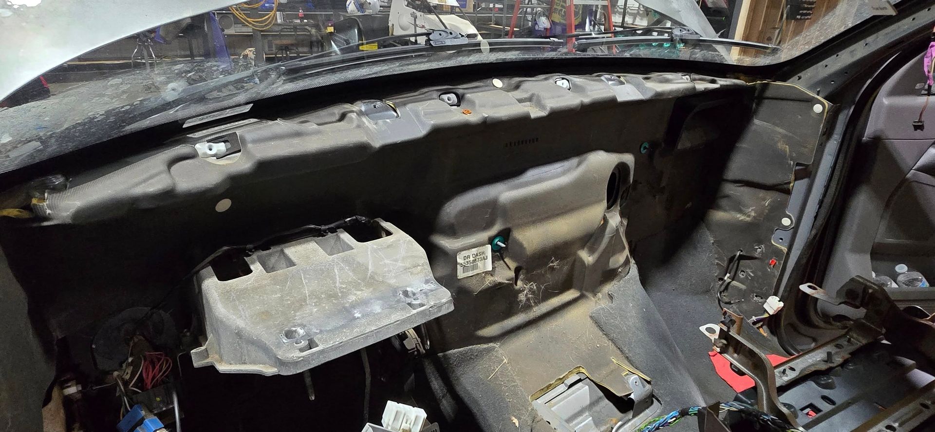 Car interior with exposed dashboard components and wiring during disassembly