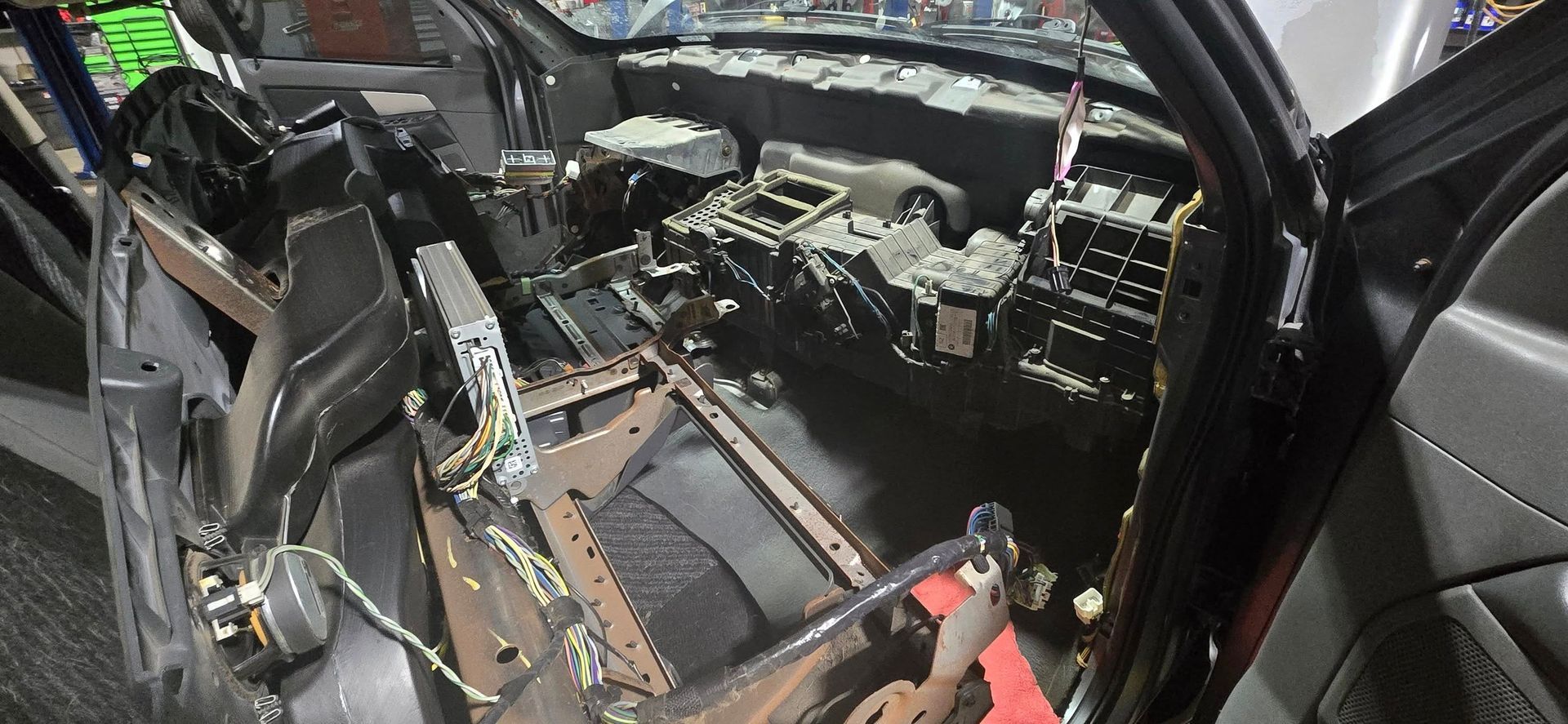 Interior of a wrecked car with deployed airbags, torn dashboard, and exposed wiring after a crash