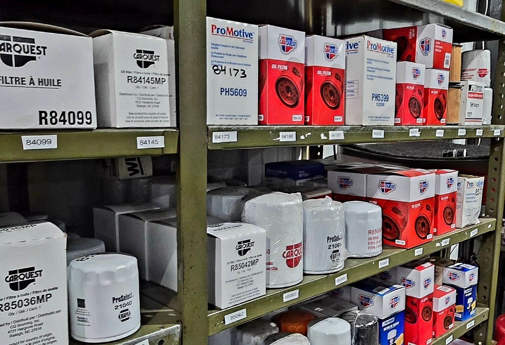 Shelves of assorted packaged goods and containers in a warehouse or store aisle.